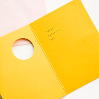 2: Yellow greeting card featuring circular cut out on front, revealing an interior message