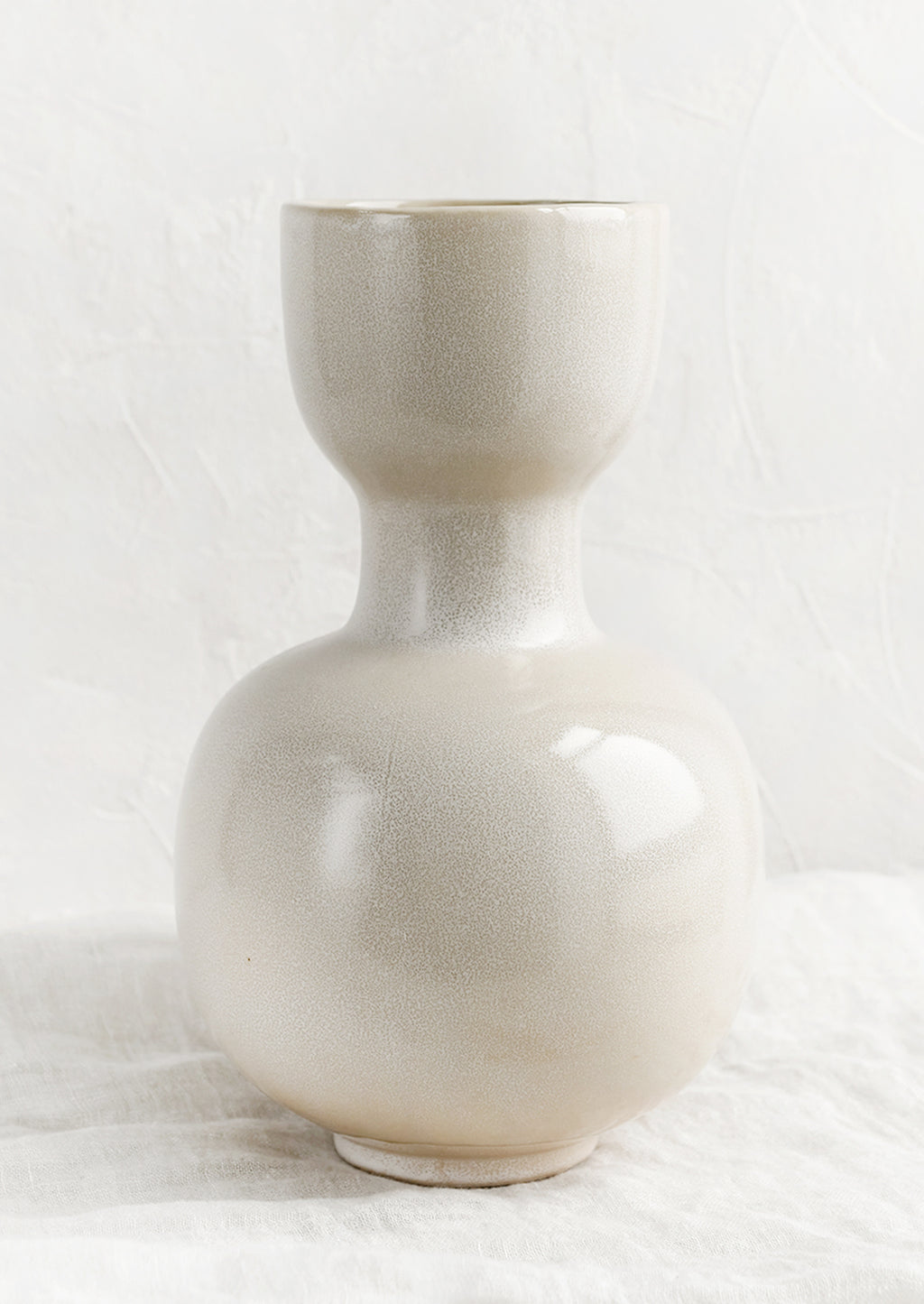 2: A cream glaze vase with cup shaped top, pinched middle and round bottom.