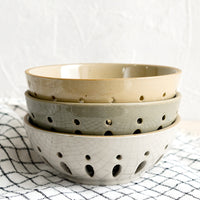 3: A stack of three ceramic berry bowls/colanders.