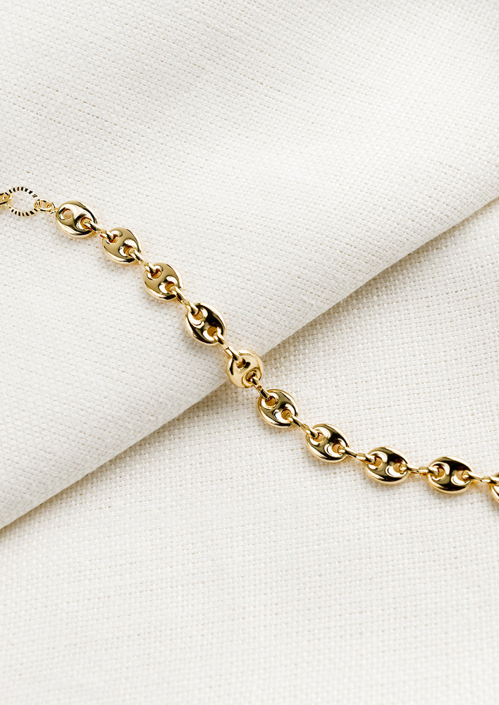 A gold bracelet with puffy mariner chain.
