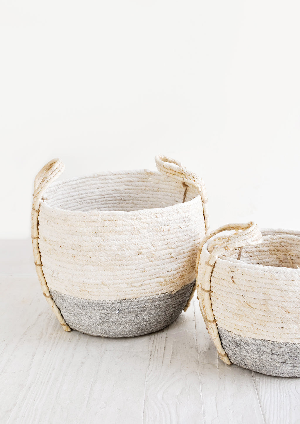 Slate / Low [Small]: Small, round storage baskets made from natural maize fiber, fiber handles attached at sides, band of contrasting grey color along bottom.