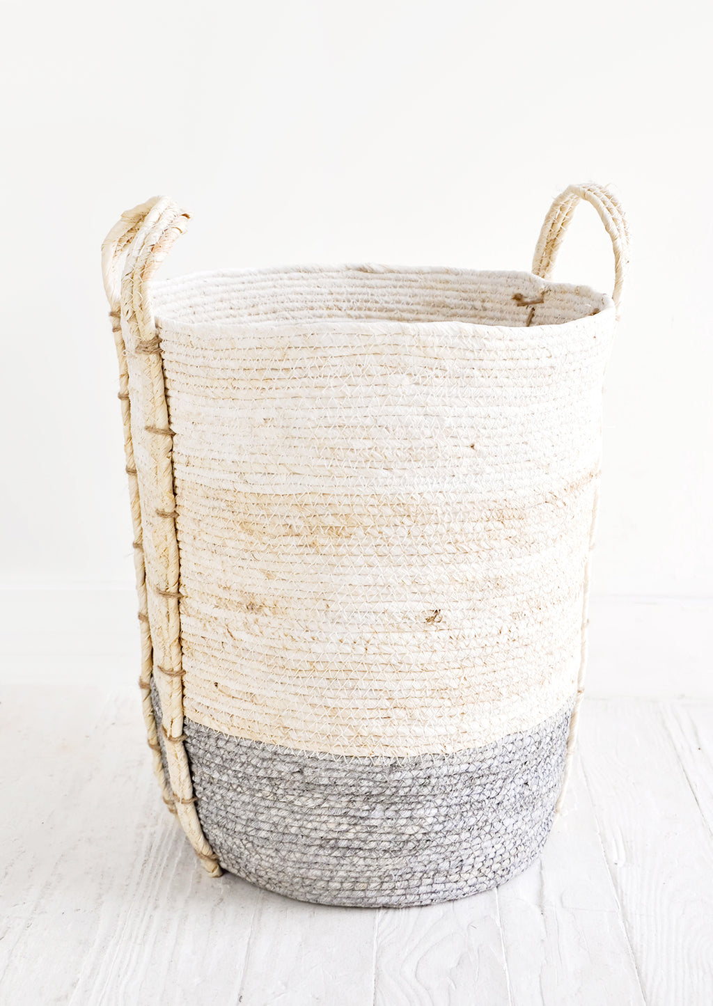 Slate / Tall [Large]: Round, tall storage basket made from natural maize fiber, fiber handles attached at sides, band of contrasting grey color along bottom.