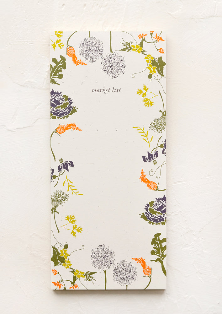 A list making notepad with "market list" printed at top with a decorative botanical border.