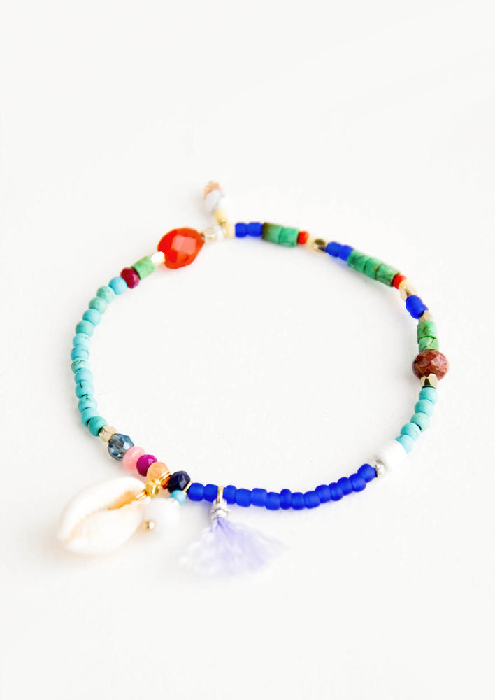 Beaded bracelet with a mix of gemstone & matte glass beads, shell & tassel charm detail