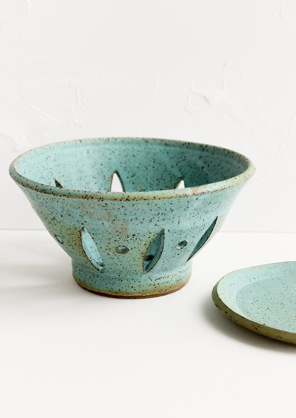 3: A ceramic berry bowl with plate in turquoise.