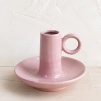 1: A pink ceramic taper candle holder.