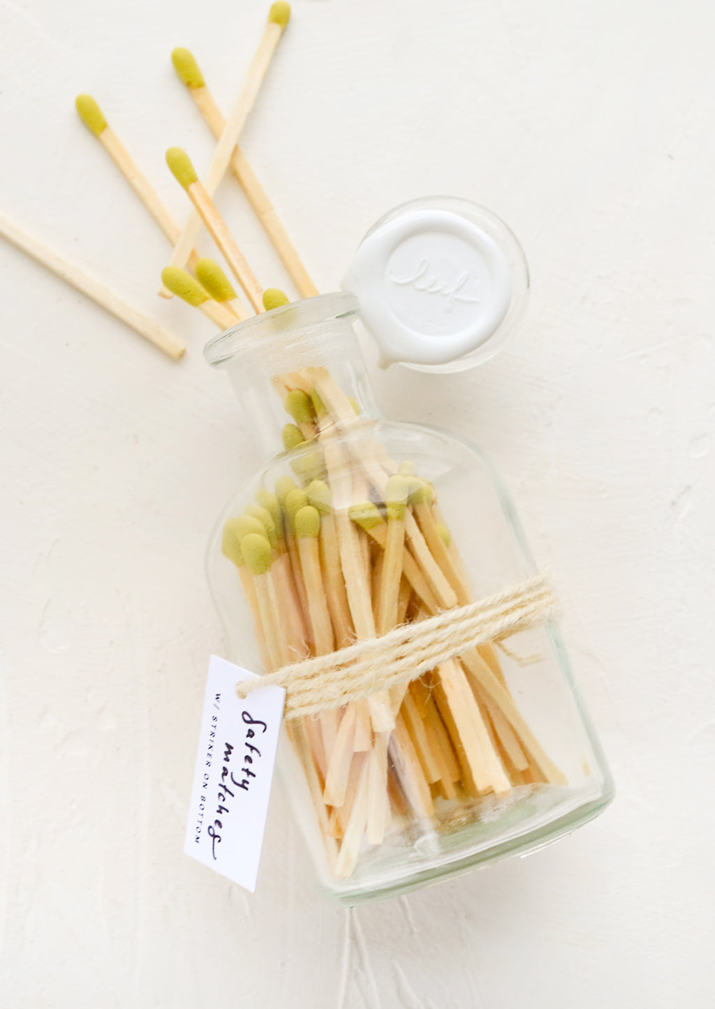 Citron: Safety matches with lime green tips in a vintage-style glass apothecary jar with white wax seal on lid.