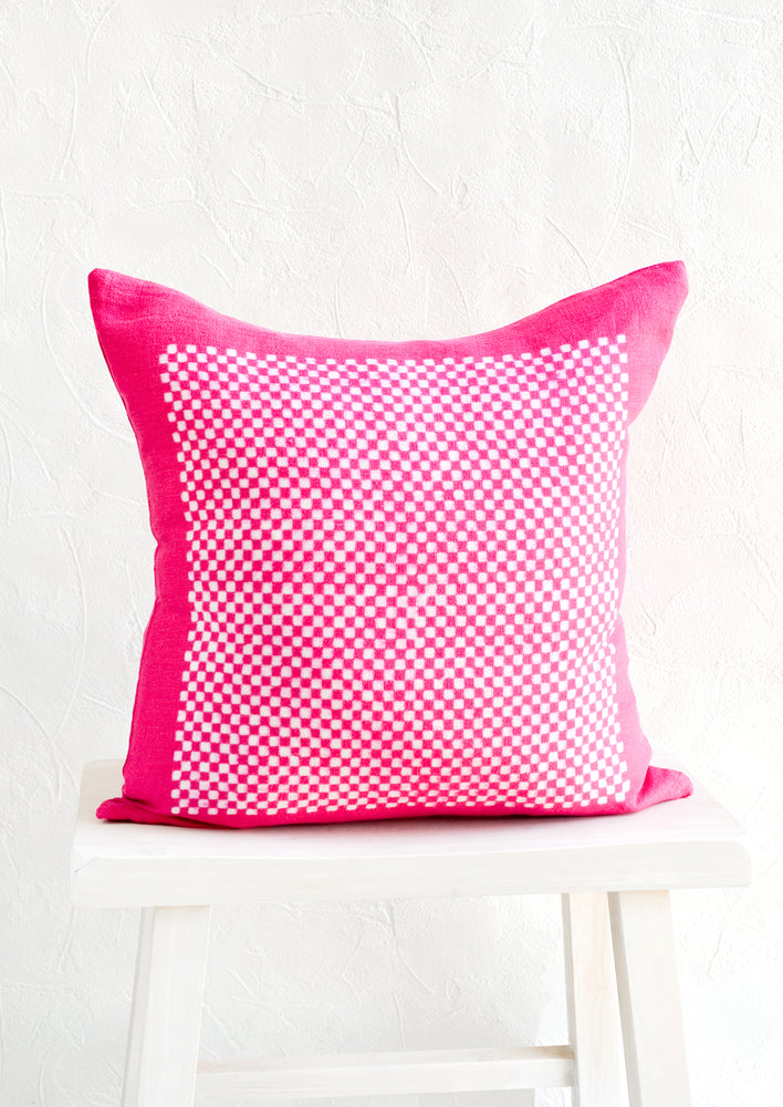 Square throw pillow in magenta linen with white checker print pattern