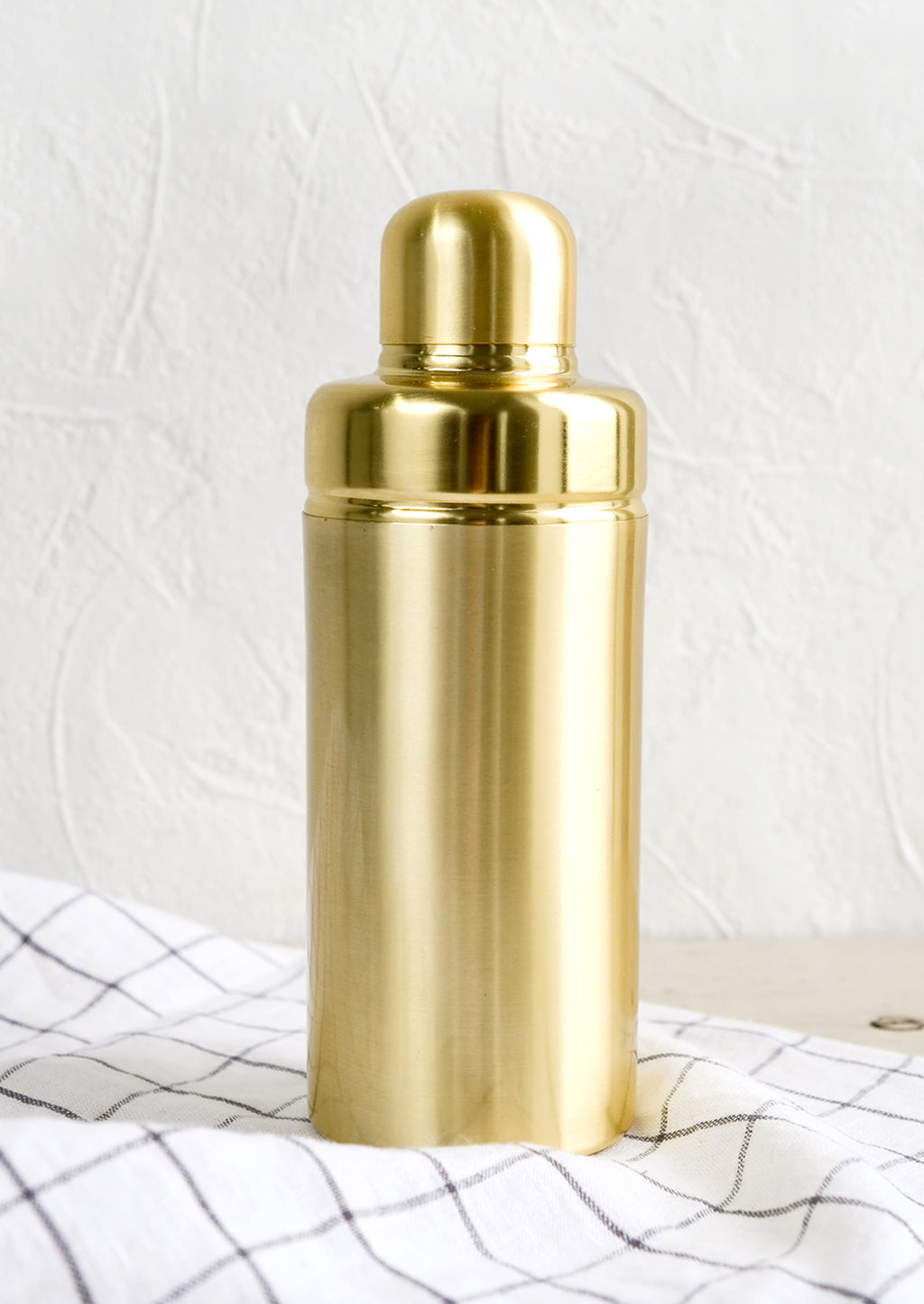 1: A cocktail shaker in satin gold metal.