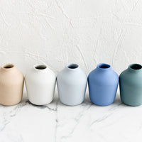 2: A row of matte porcelain bud vases in different colors.