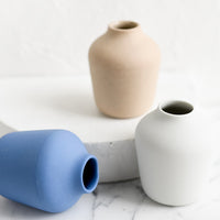 1: Three matte porcelain bud vases.