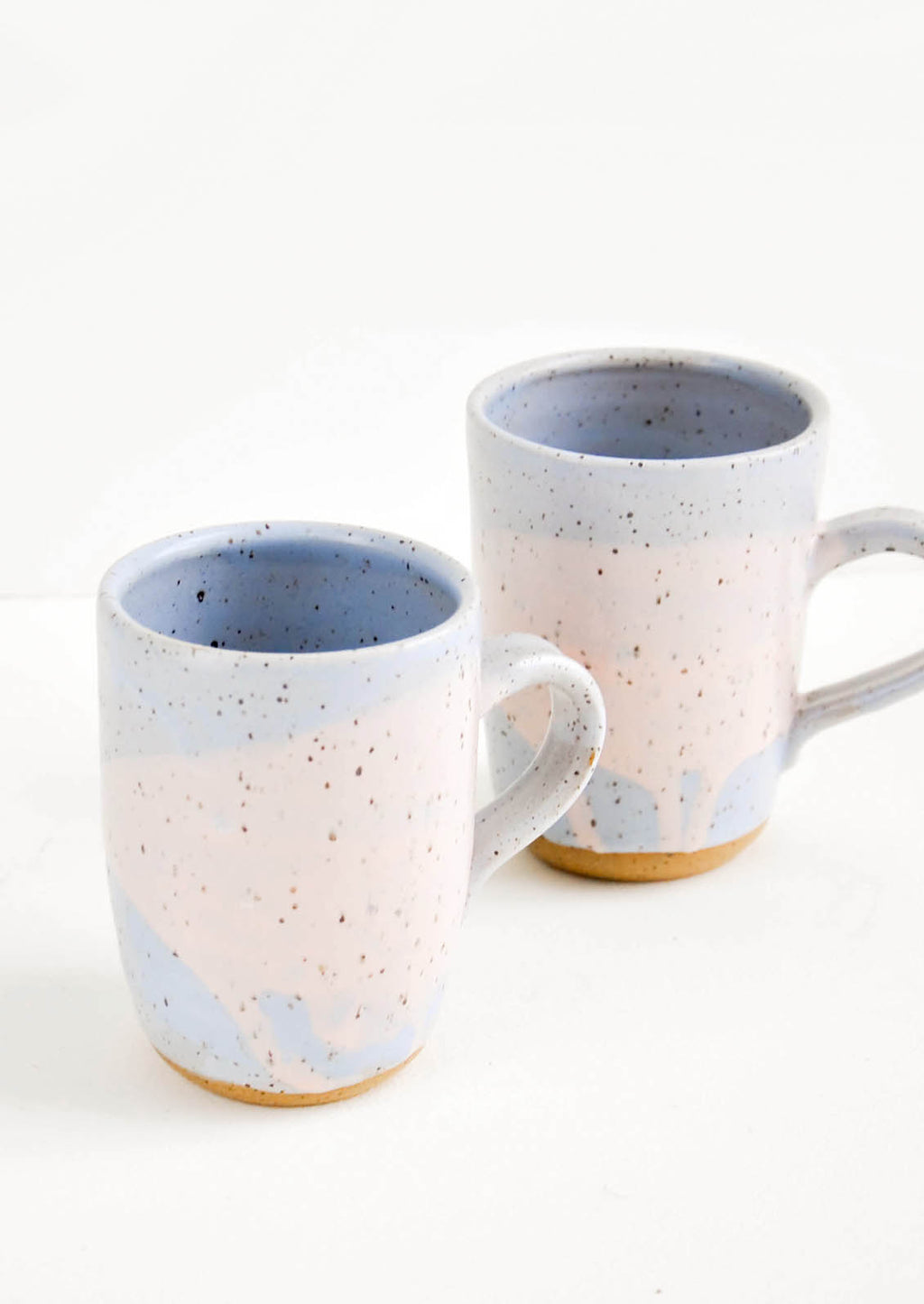 Periwinkle / Pink: Two ceramic mugs in blue and pink with brown speckles.