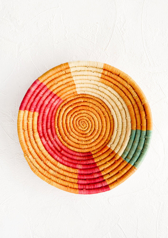 Woven raffia bowl in mustard, pink, natural and turquoise geometric pattern