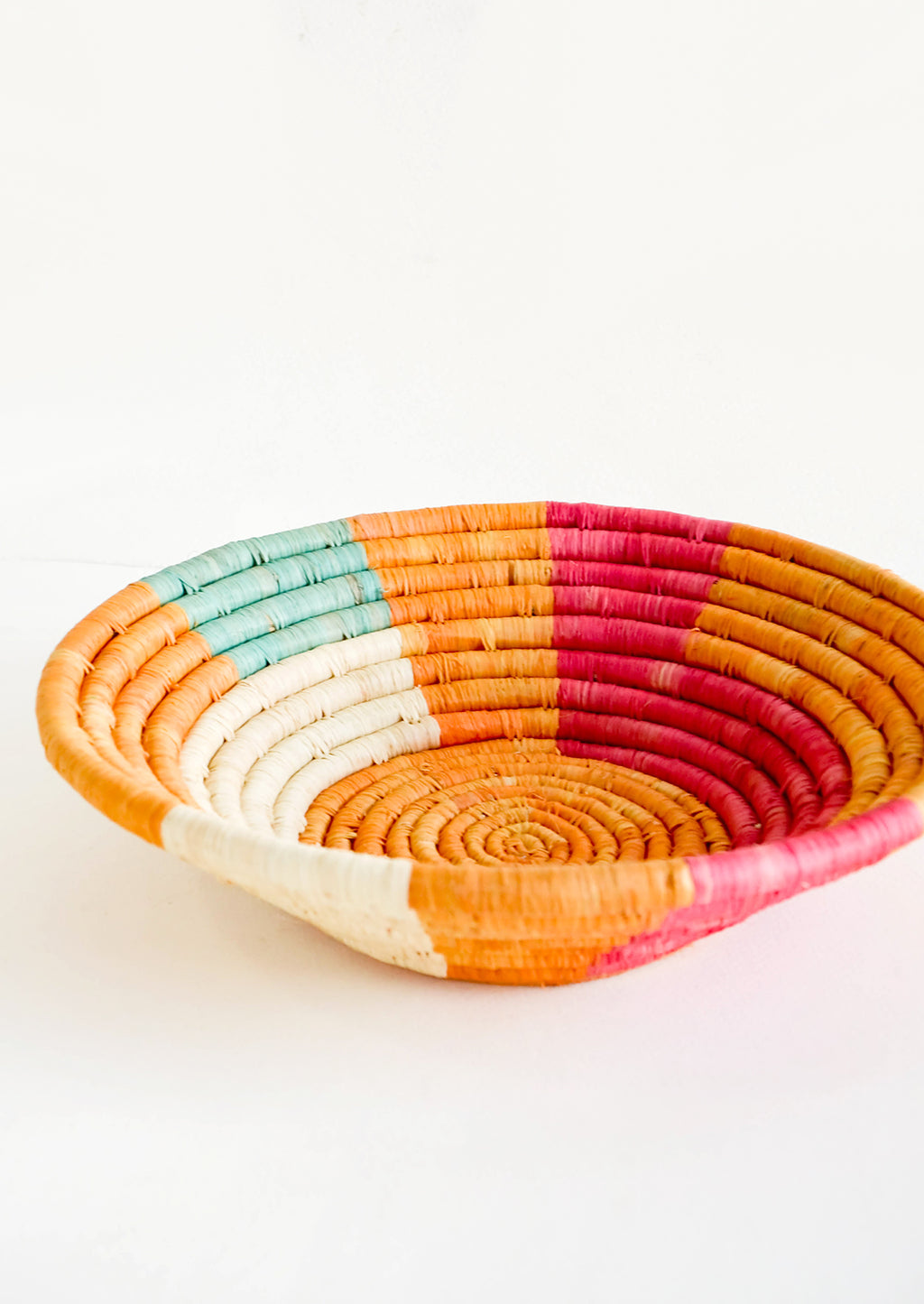 2: Shallow raffia bowl in mustard, pink, natural and turquoise geometric pattern