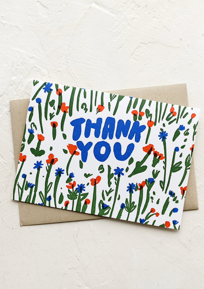 A floral print greeting card in primary hues reading "Thank you".