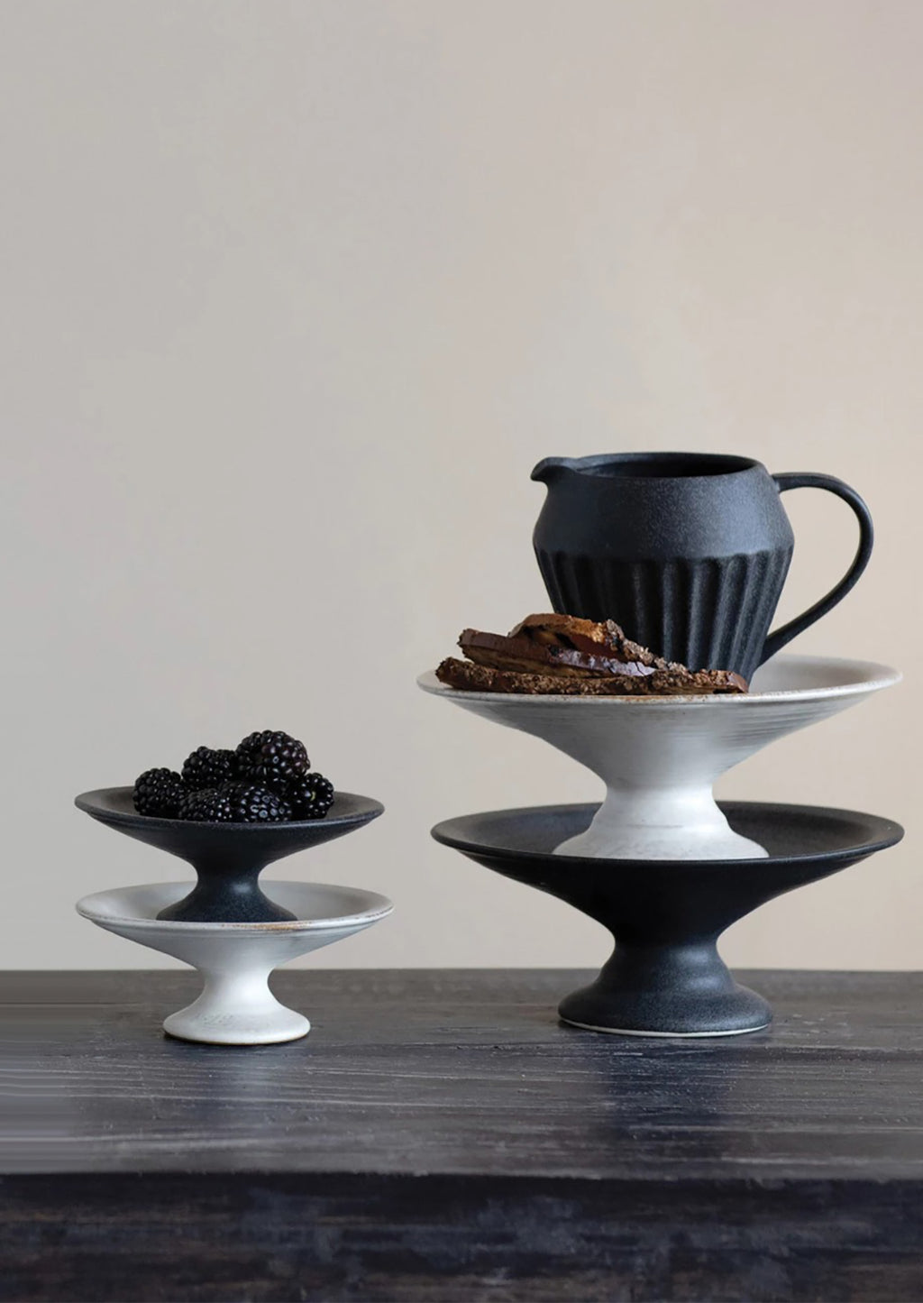 Large / Black: Ceramic pedestal risers in black and white styled with food.