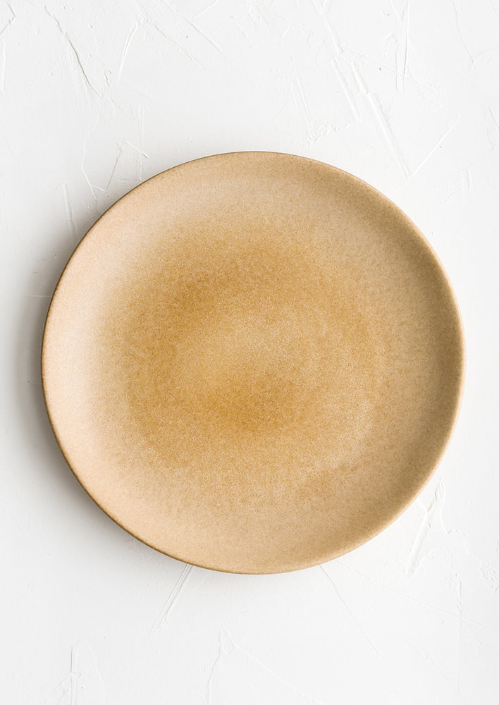 1: A round ceramic dinner plate in matte chocolate brown glaze.