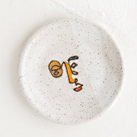 Multicolor: A small speckled ceramic trinket dish with and painted expressionist faces.