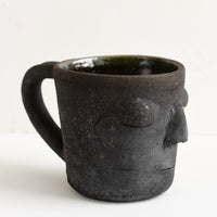 Black: A clay mug in matte black color in face shape.