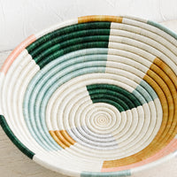 3: A round bowl made from woven sweetgrass in white, multiple pastels and silver.