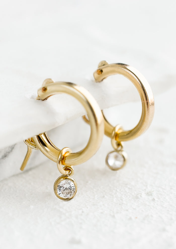 A pair of gold hoops with single crystal bezel detail.