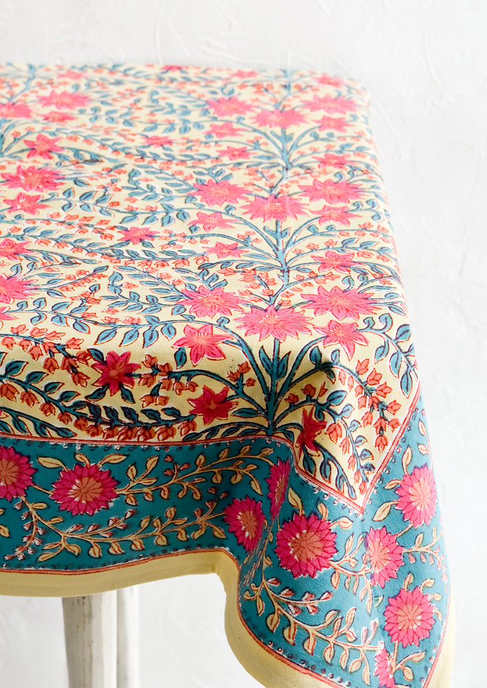 A vibrantly colored block printed tablecloth with floral print.
