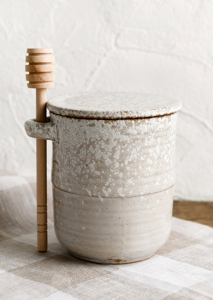2: A ceramic honey jar in grey ceramic with white speckles.