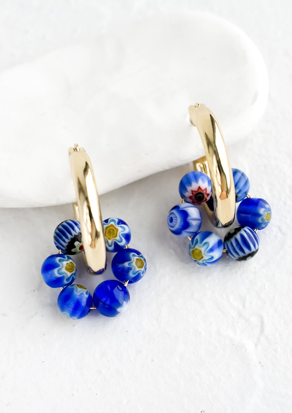 Cobalt Multi: A pair of gold hoop earrings with cobalt millefiore glass beads.