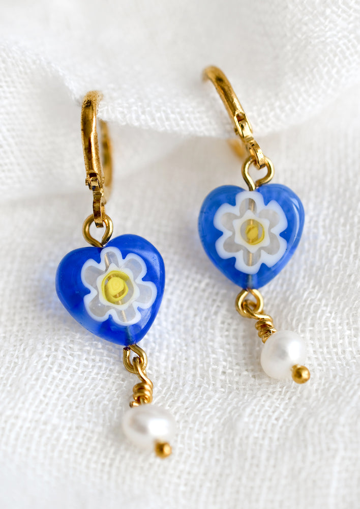 A pair of earrings with blue floral millefiore glass bead and pearl detail.