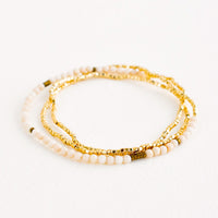 White Fossil: A single strand bracelet of gold and ivory beads wrapped upon itself in three layers. 