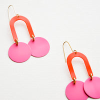 Coral / Pink: Two-toned pink earrings form a curved arc with two discs at each end.
