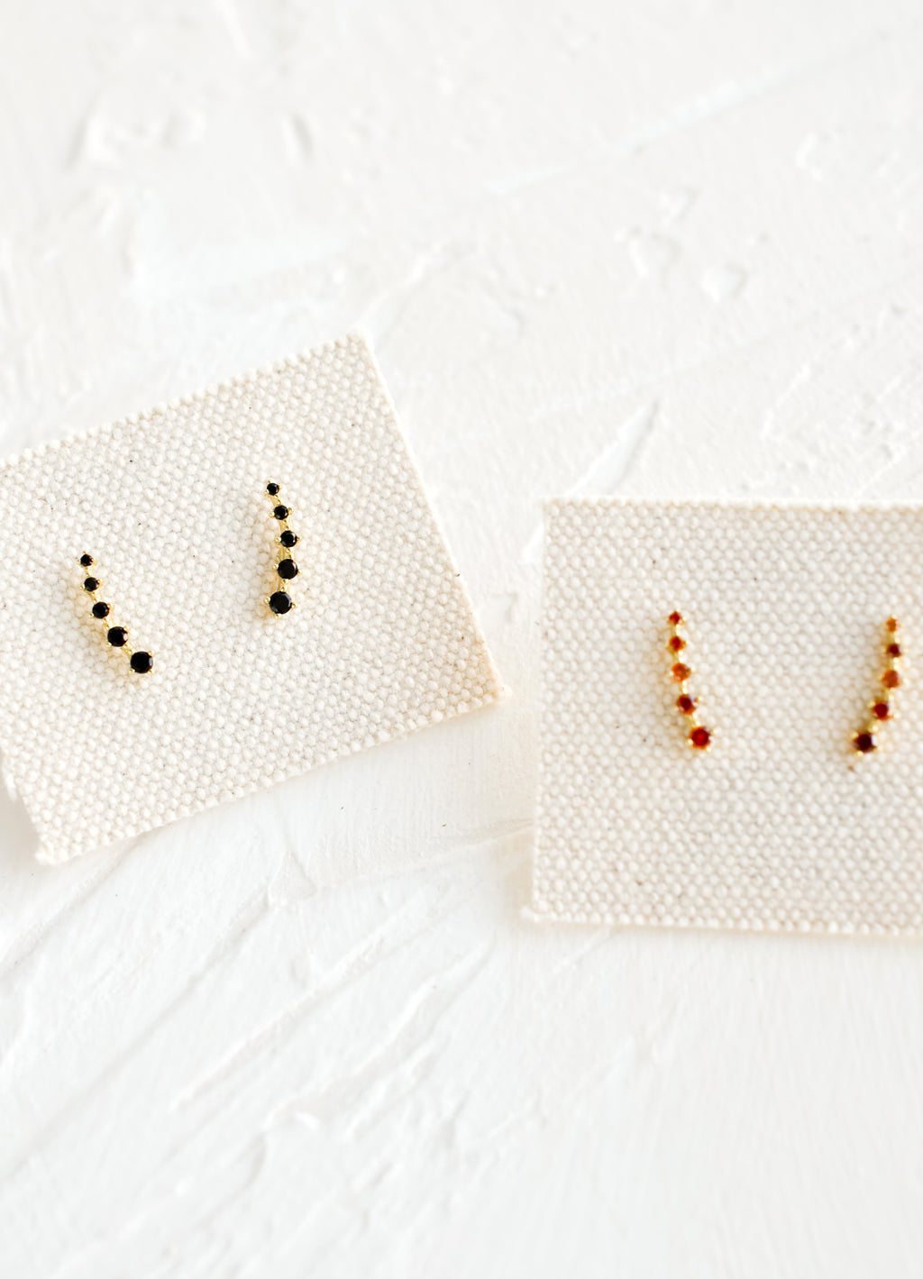 Black: Black and amber crystal stud earrings on canvas cards.