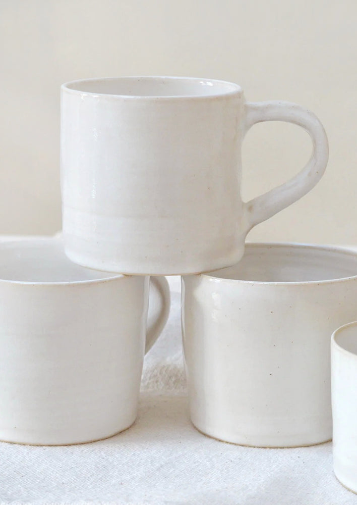 A stack of white ceramic mugs.