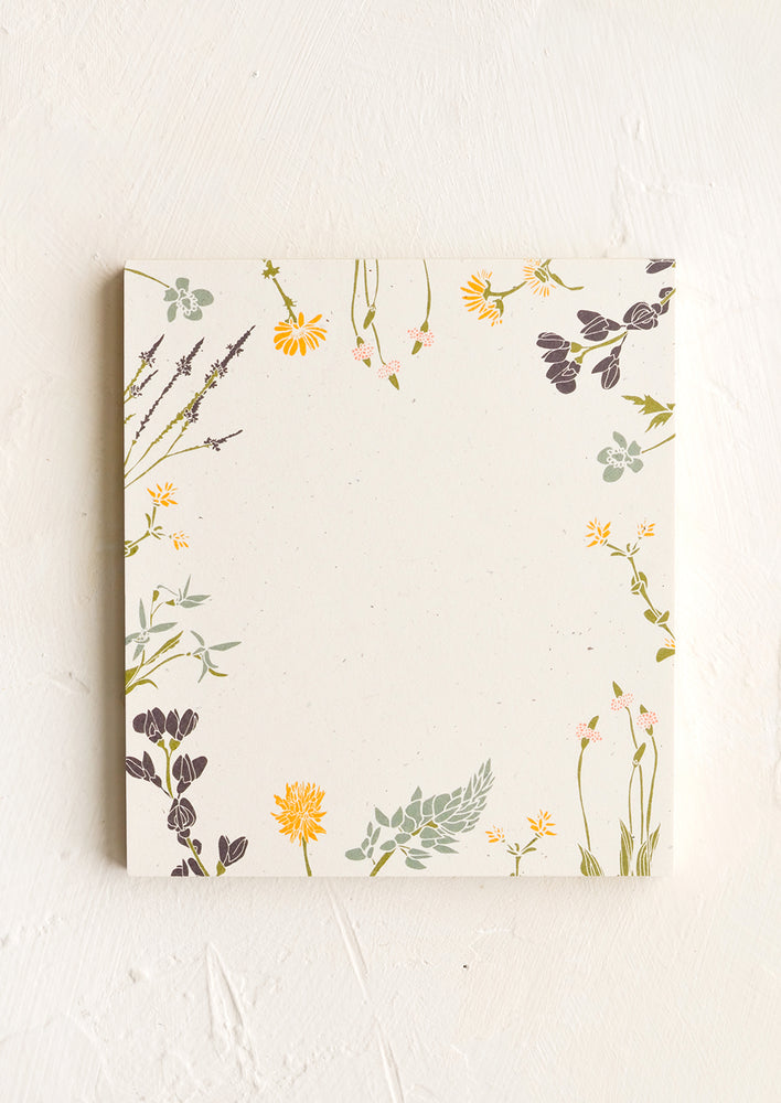 A small square notepad with wildflower botanical border.
