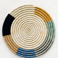 Colorblock Border: A raffia trivet with natural center and blue and tan border.