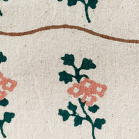 4: A natural cotton napkin with wavy brown line and green/peach flower print.