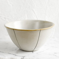 1: A ceramic bowl in white with thin black stripe detail.