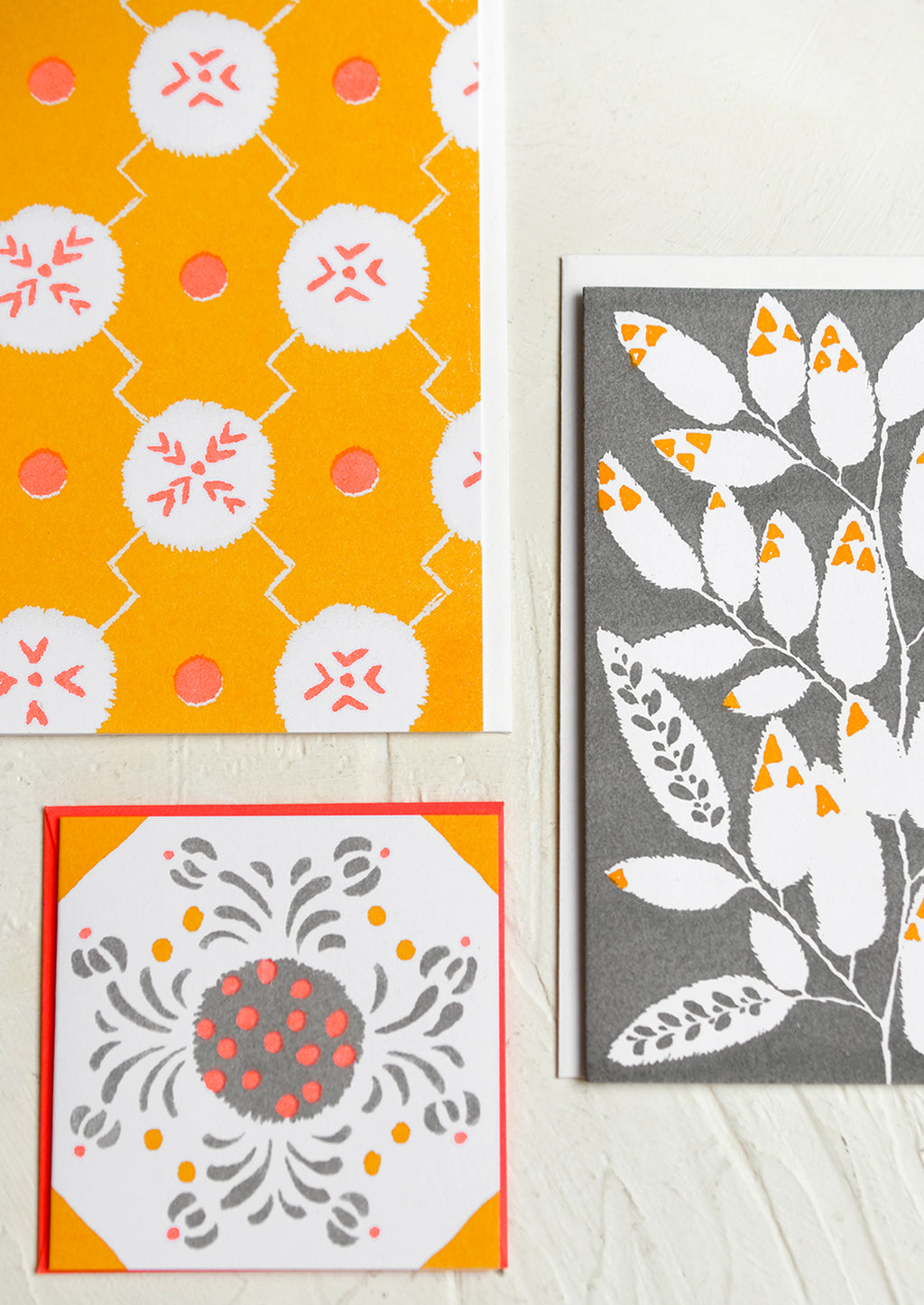 2: A patterned risograph printed card set in grey, coral and orange.