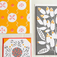2: A patterned risograph printed card set in grey, coral and orange.