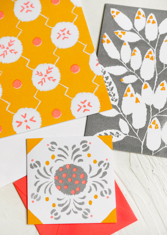 A patterned risograph printed card set in grey, coral and orange.