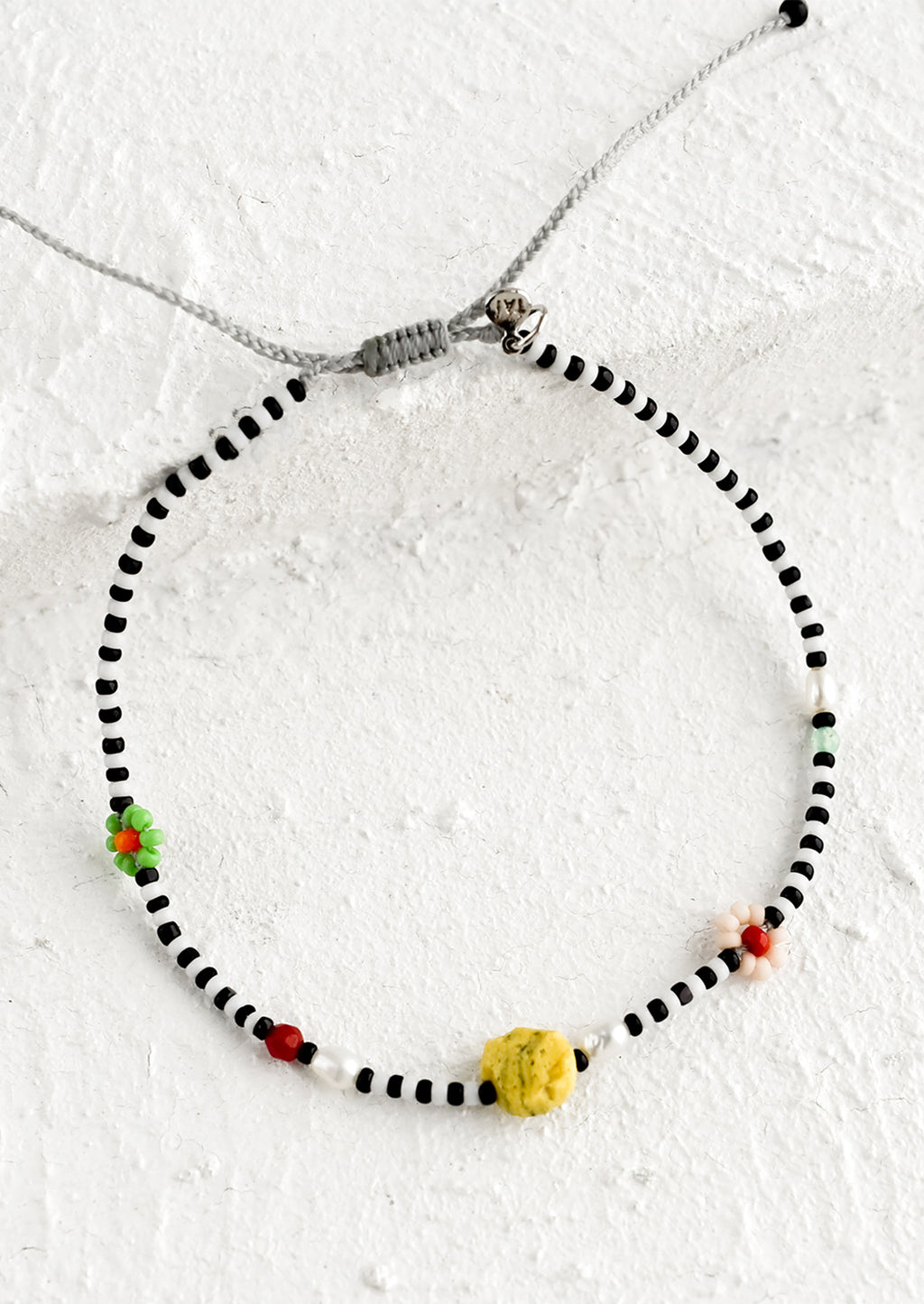 Black & White / Yellow Coral: A black and white seed bead bracelet with mixed flower and gemstone beads.