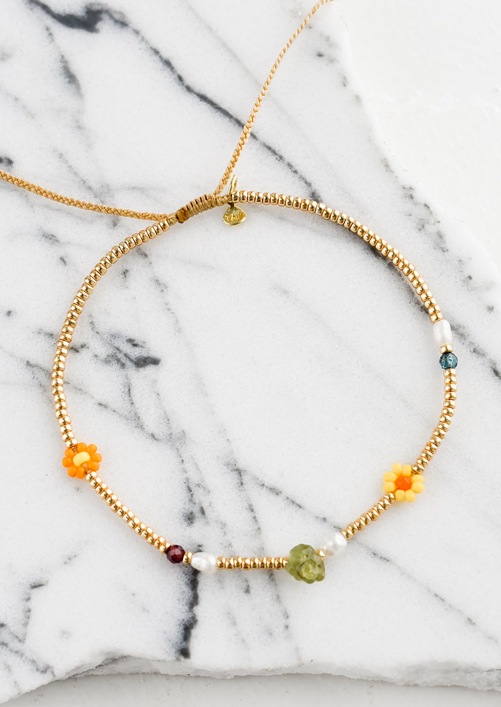 Gold / Peridot: A gold seed bead bracelet with mixed flower and gemstone beads.