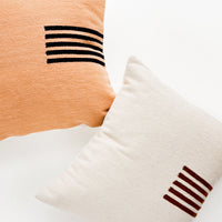 1: Square wool throw pillows with contrasting small stripe detail at side.