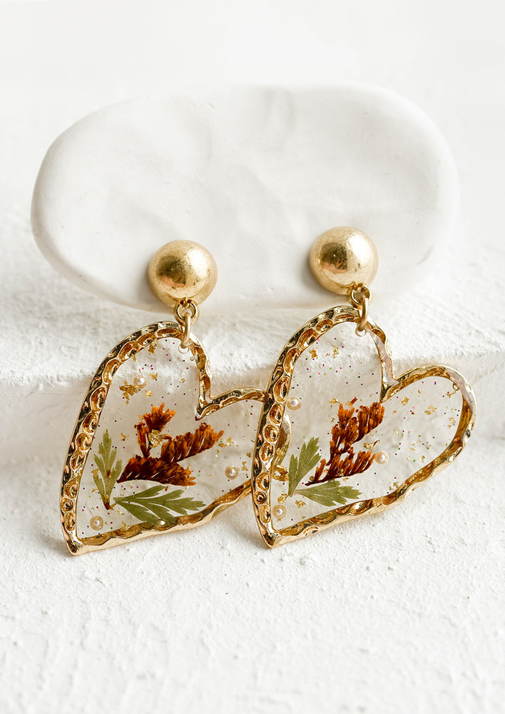 1: A pair of resin earrings with gold border in heart shape.