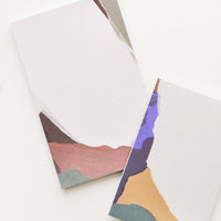 4: Two notepads, decorated with colorful abstract shapes.