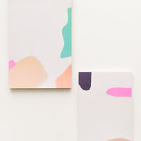 3: Two notepads, decorated with colorful abstract shapes.