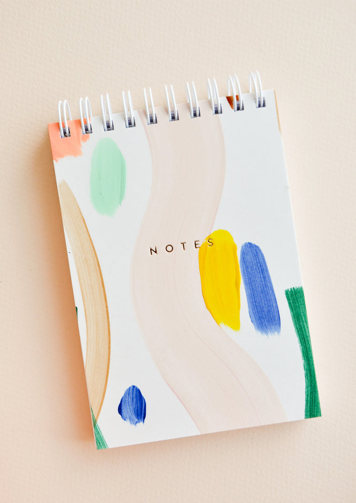 1: Small spiral bound notepad with cover decorated in colorful, hand-painted paint strokes