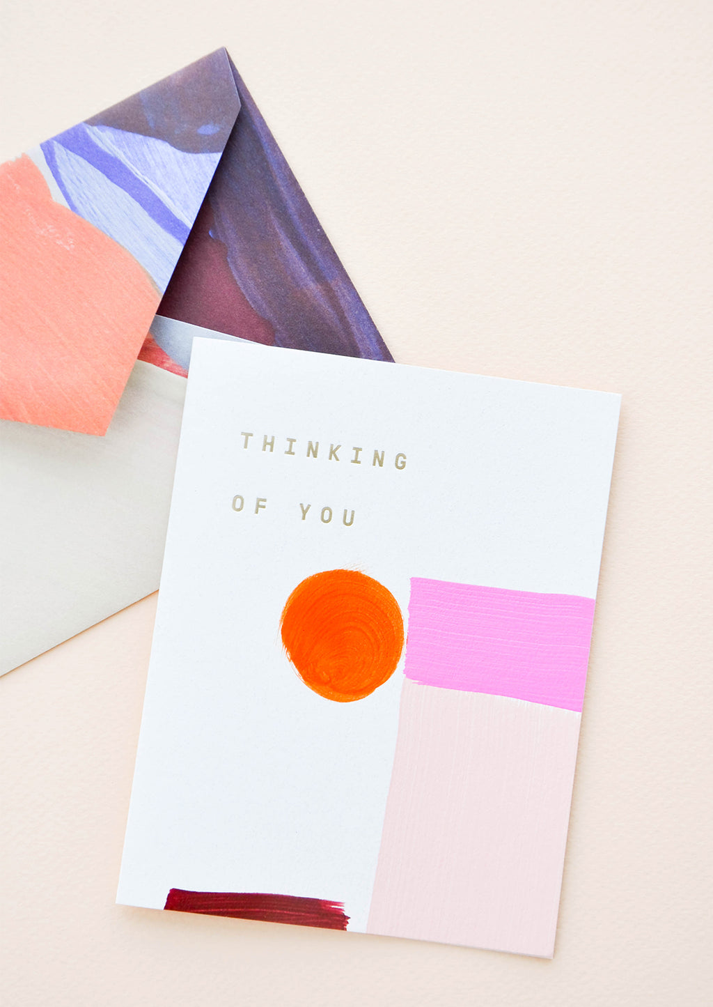 2: Painted shapes in shades of pink on white greeting card with words "Thinking Of You" in gold foil. Shown with envelope painted with abstract lines.
