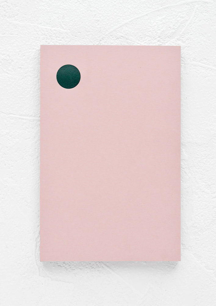A pink notepad with green dot at top left corner.