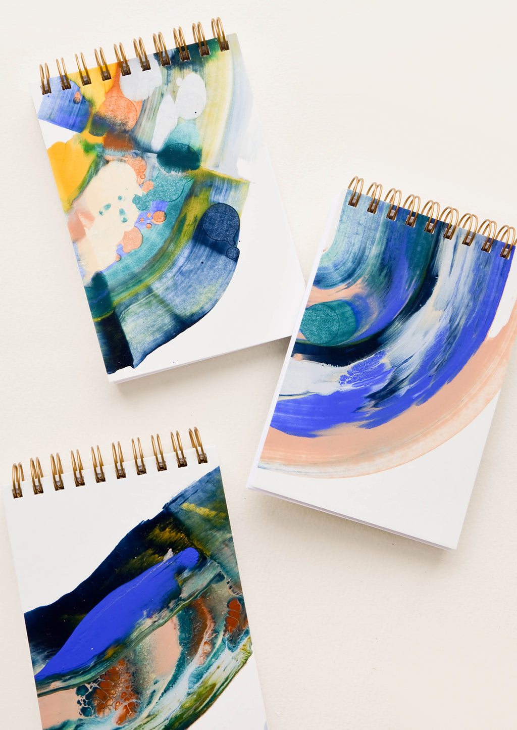 1: Small, pocket-size spiral notepads with covers painted in earth toned paint swirls